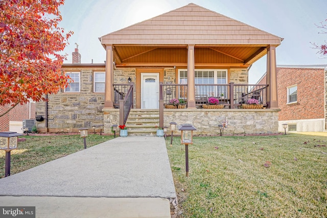 view of front of property with a front lawn and central air condition unit