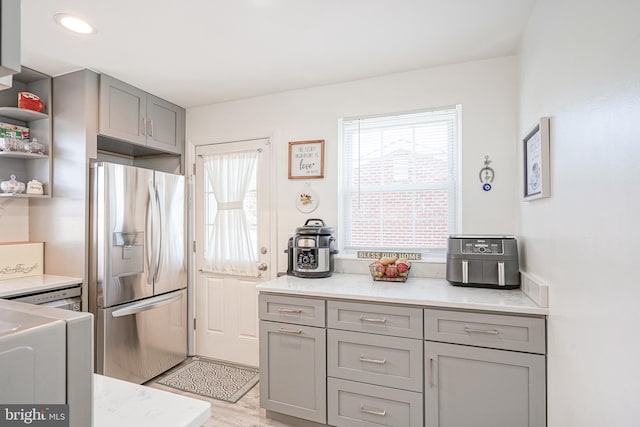 kitchen featuring light hardwood / wood-style flooring, gray cabinetry, and stainless steel fridge