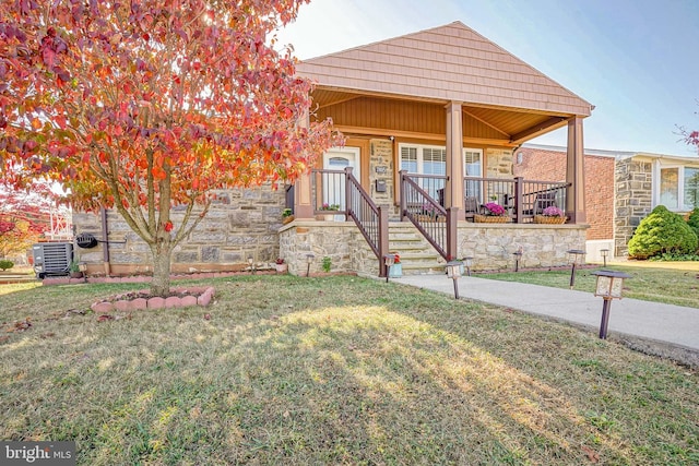 bungalow-style house featuring central AC unit, a front lawn, and covered porch