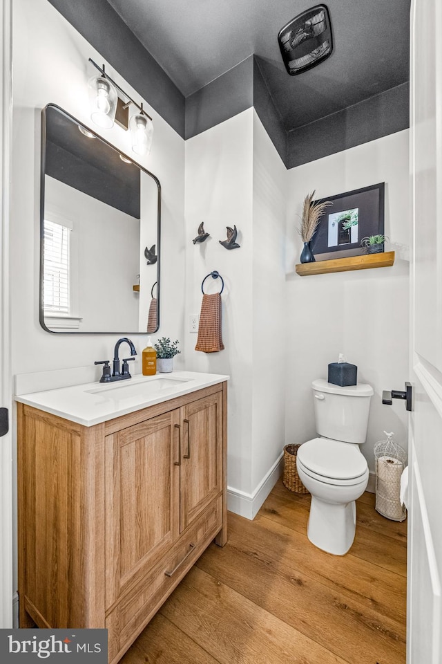 bathroom with vanity, hardwood / wood-style floors, and toilet