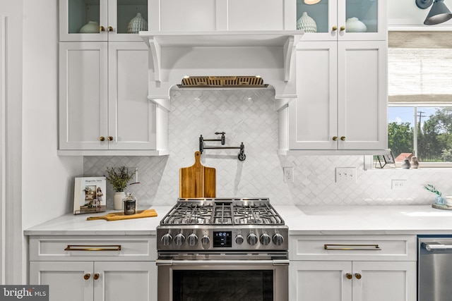 kitchen featuring stainless steel appliances, tasteful backsplash, and white cabinets