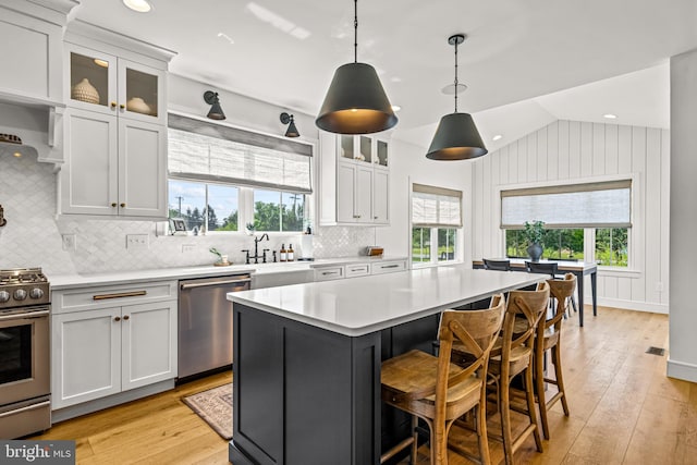 kitchen with white cabinetry, stainless steel appliances, a center island, and plenty of natural light