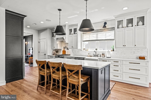 kitchen featuring light hardwood / wood-style flooring, white cabinetry, tasteful backsplash, and a center island