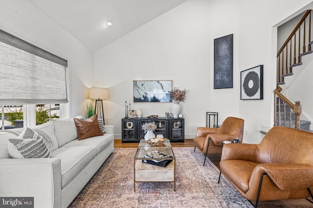 living room with high vaulted ceiling and hardwood / wood-style floors