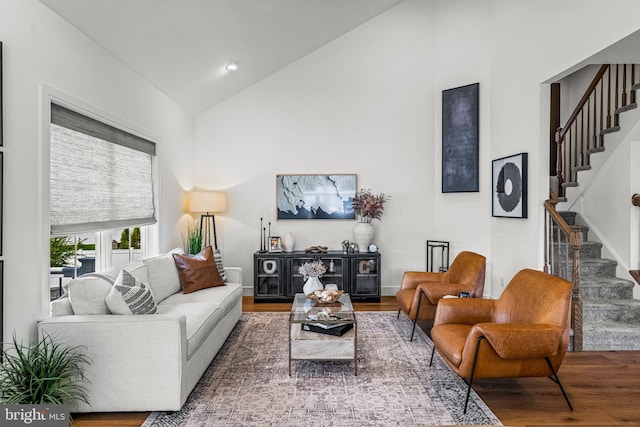 living room featuring high vaulted ceiling and wood-type flooring