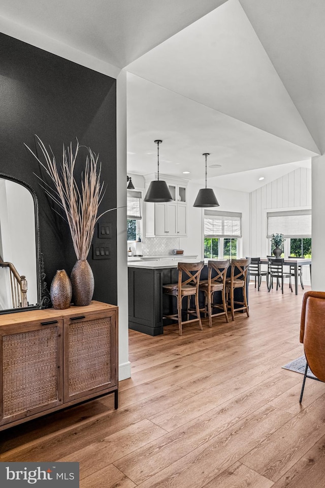 dining space with light hardwood / wood-style flooring and vaulted ceiling