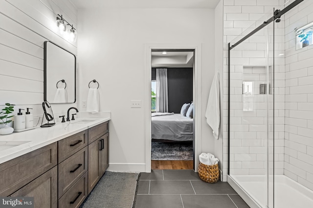 bathroom with a shower with door, tile patterned floors, and vanity