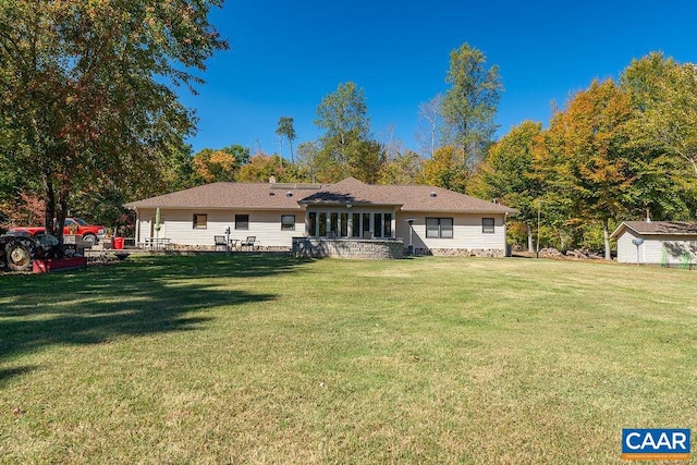 rear view of house with a storage shed and a lawn