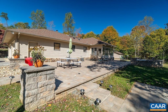 back of house featuring a patio area and a lawn