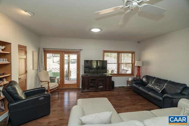 living room featuring ceiling fan, a wealth of natural light, and dark hardwood / wood-style floors