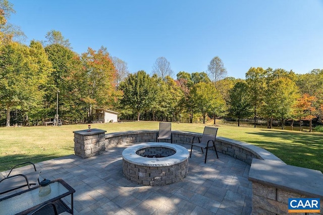 view of patio with an outdoor fire pit and a shed