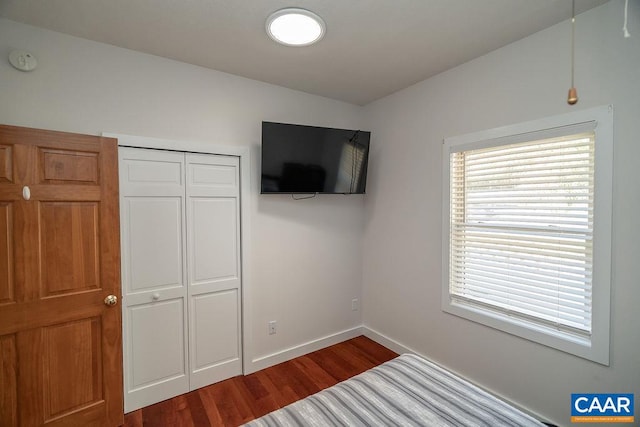 unfurnished bedroom featuring dark wood-type flooring and a closet