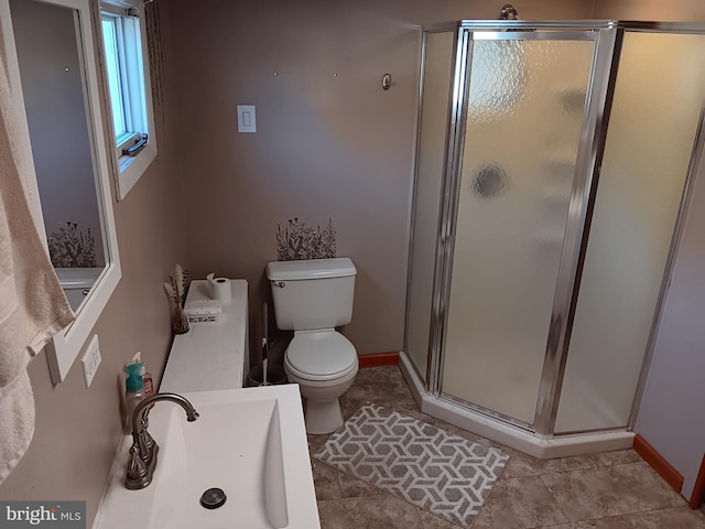 bathroom with sink, tile patterned flooring, toilet, and walk in shower