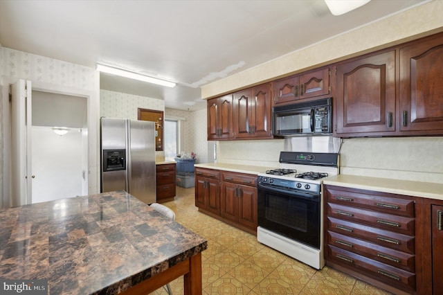 kitchen featuring stainless steel fridge and white gas stove