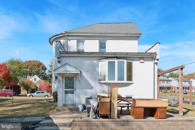 rear view of property with a lawn