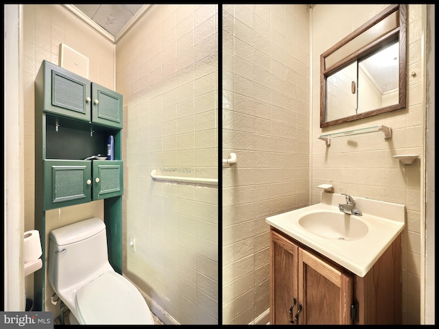 bathroom with tile walls, vanity, ornamental molding, and toilet