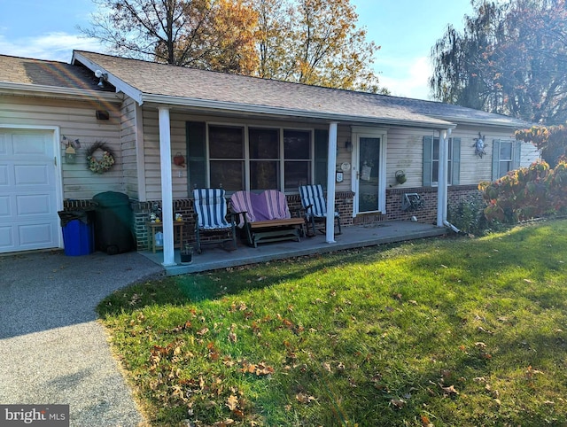 view of front of house featuring a garage, a patio area, and a front lawn