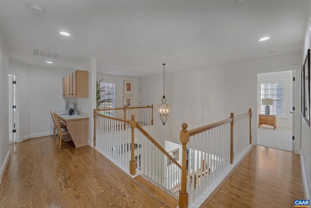 hall featuring a notable chandelier and light wood-type flooring