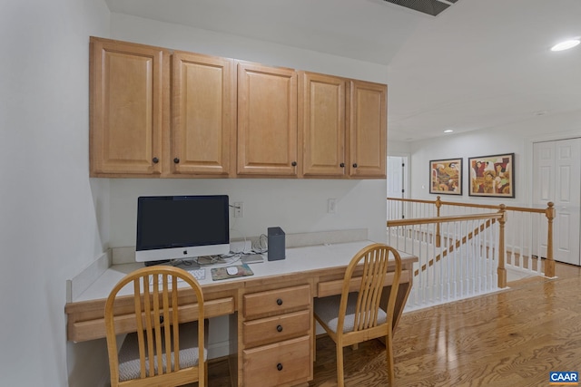 office with light hardwood / wood-style flooring and built in desk