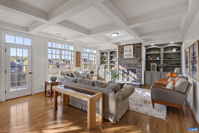 living room featuring beamed ceiling, a fireplace, and wood-type flooring