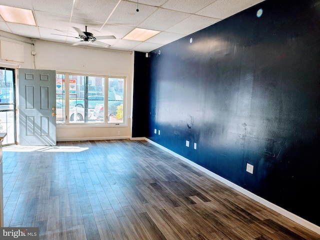 spare room with a drop ceiling, wood-type flooring, and ceiling fan