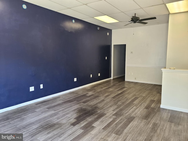 unfurnished room with a paneled ceiling, wood-type flooring, and ceiling fan