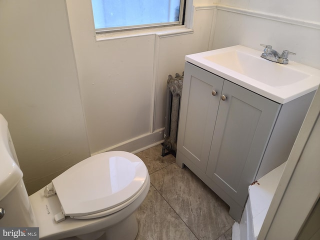 bathroom with toilet, vanity, and tile patterned flooring