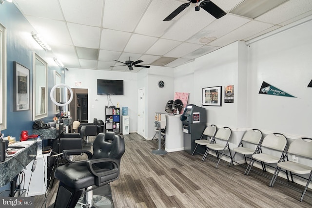 interior space featuring a drop ceiling, wood-type flooring, and ceiling fan