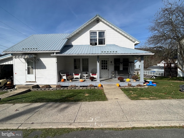 exterior space featuring a porch, metal roof, and a yard