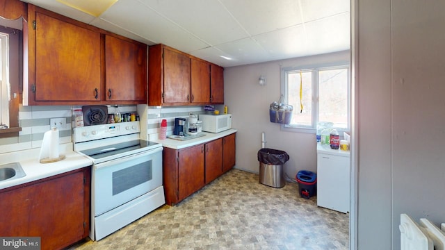 kitchen featuring white appliances, tasteful backsplash, and radiator heating unit