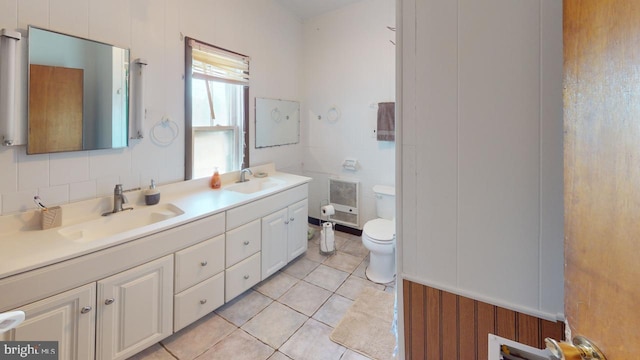 bathroom with toilet, vanity, tile patterned floors, and heating unit