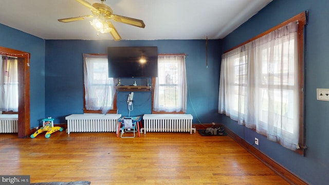 interior space featuring light hardwood / wood-style floors, radiator heating unit, and plenty of natural light