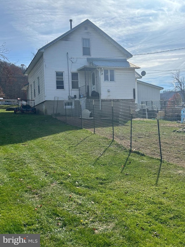 rear view of house featuring a lawn