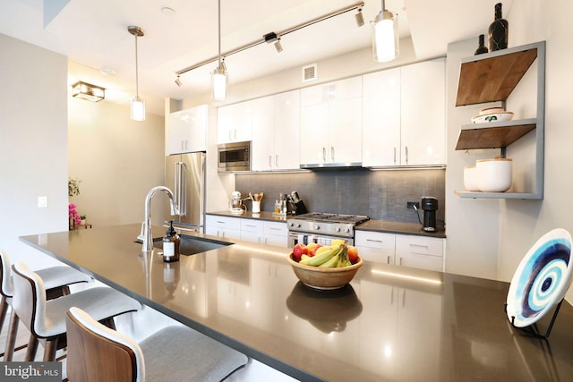 kitchen featuring tasteful backsplash, white cabinetry, a kitchen bar, pendant lighting, and high end appliances