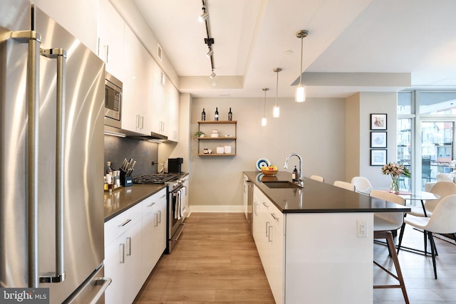 kitchen with white cabinets, a kitchen breakfast bar, and appliances with stainless steel finishes