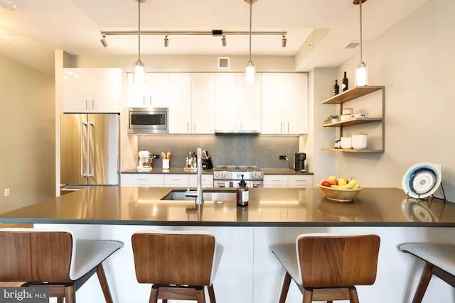 kitchen with white cabinets, high quality appliances, and pendant lighting