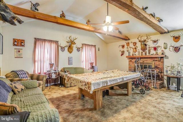 playroom with beamed ceiling, a brick fireplace, carpet floors, and ceiling fan