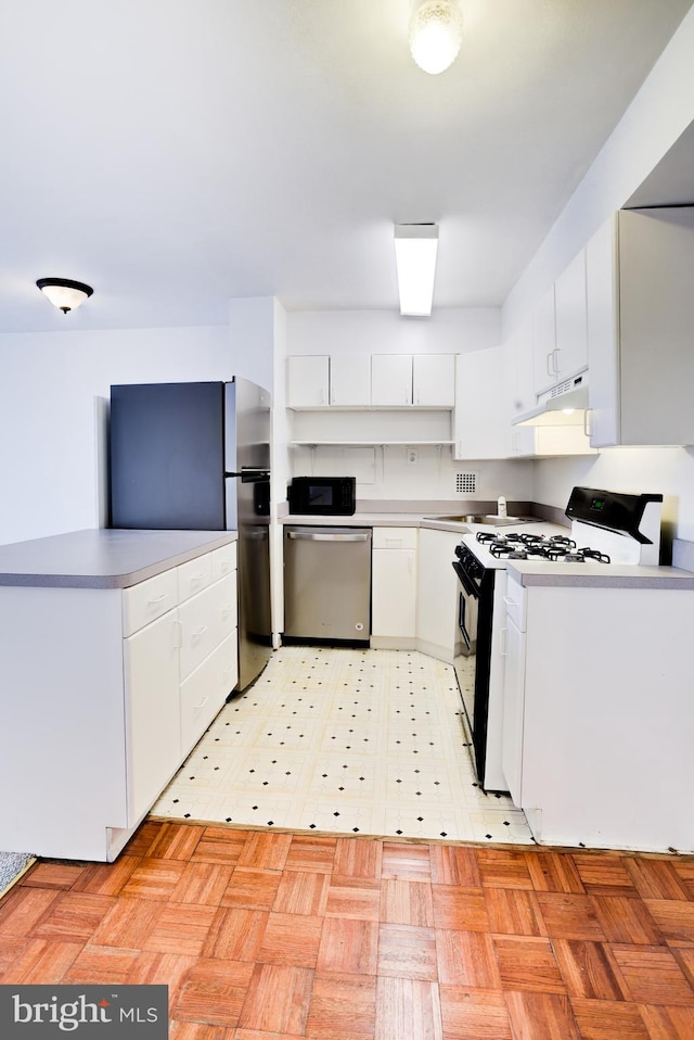 kitchen with light parquet floors, white cabinets, and stainless steel appliances