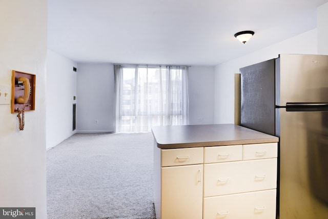 kitchen with light colored carpet and stainless steel fridge