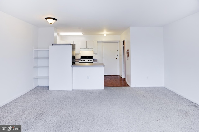 kitchen featuring dark carpet, black range with gas stovetop, white cabinets, and white fridge