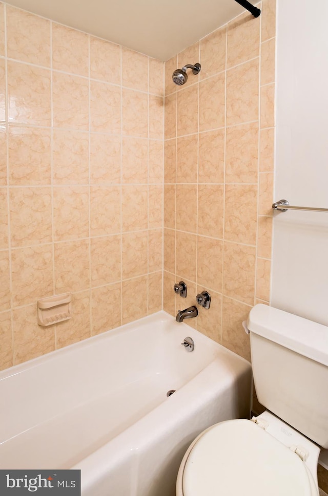 bathroom with tiled shower / bath combo and toilet