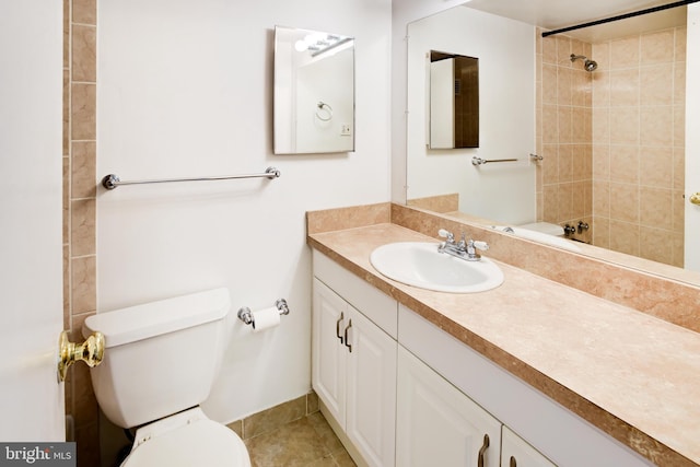 bathroom featuring toilet, vanity, a tile shower, and tile patterned floors