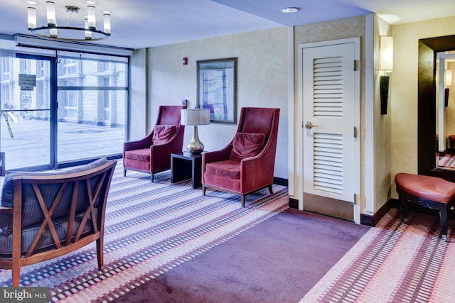 sitting room featuring carpet flooring and an inviting chandelier