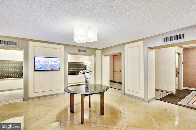 interior space featuring crown molding, a textured ceiling, a mail area, and hardwood / wood-style floors