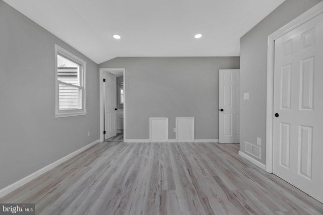 interior space featuring light wood-type flooring and lofted ceiling