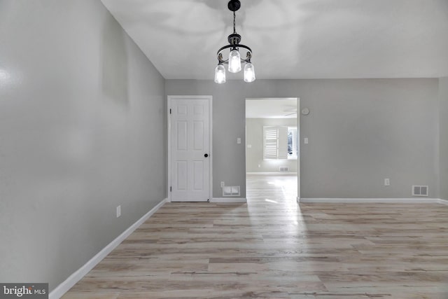 unfurnished dining area with light wood-type flooring and a chandelier