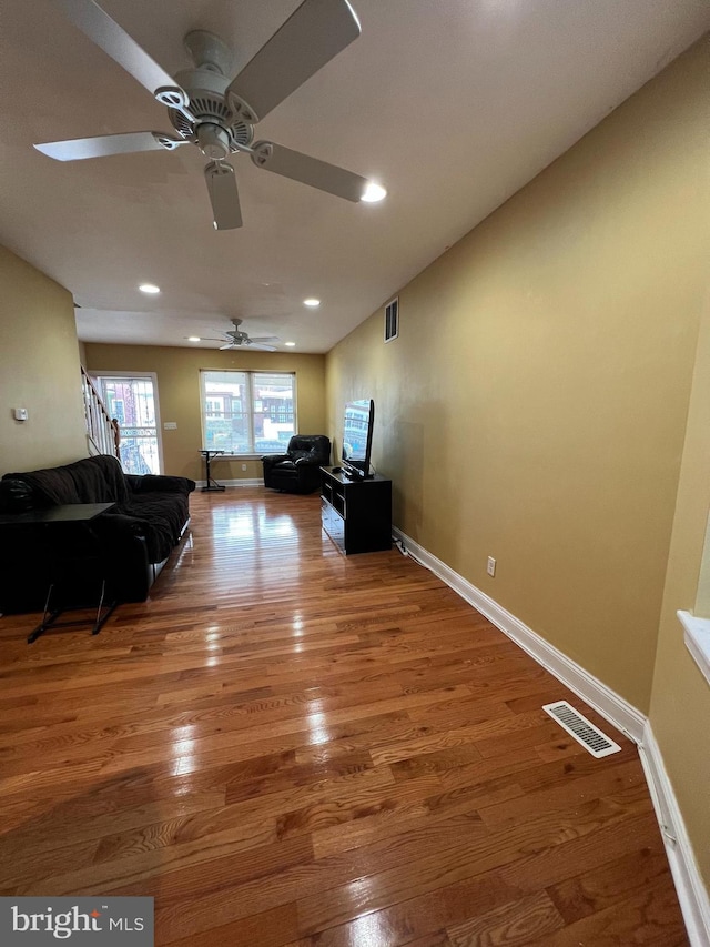 living room featuring hardwood / wood-style flooring and ceiling fan