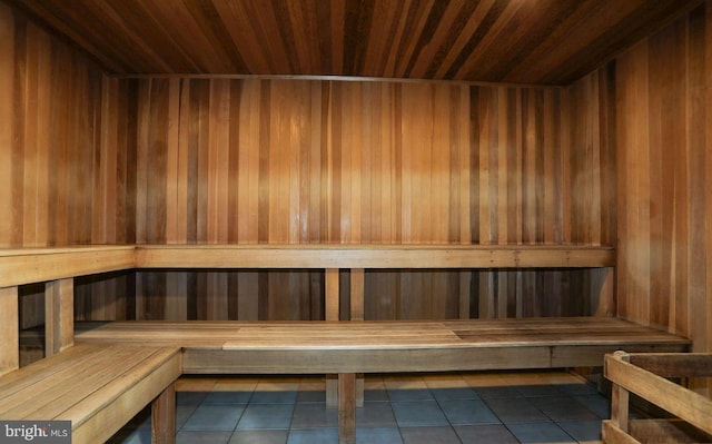 view of sauna / steam room featuring wood ceiling, wood walls, and tile patterned flooring