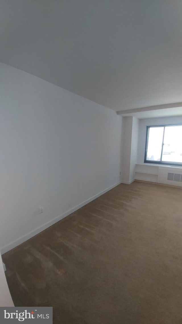 carpeted spare room featuring baseboards and visible vents