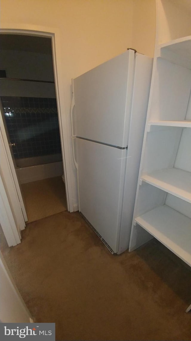 kitchen featuring white cabinetry, carpet, and white refrigerator